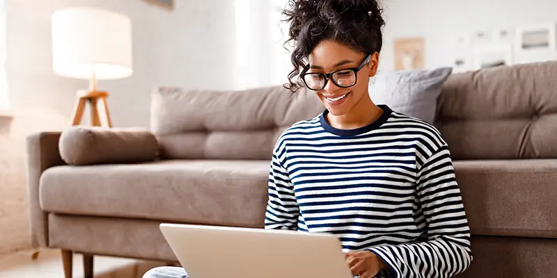 a happy woman using a laptop computer